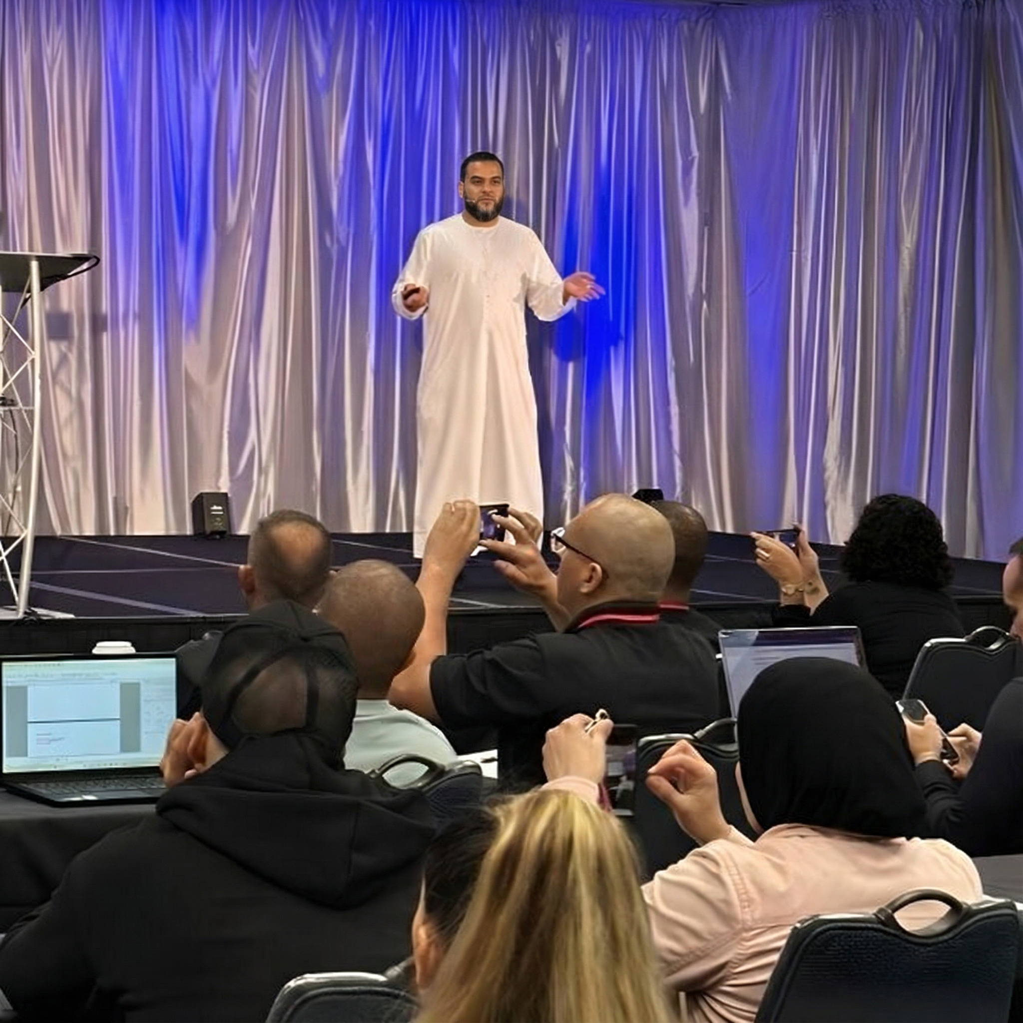 Muhammad Asmal speaking on stage